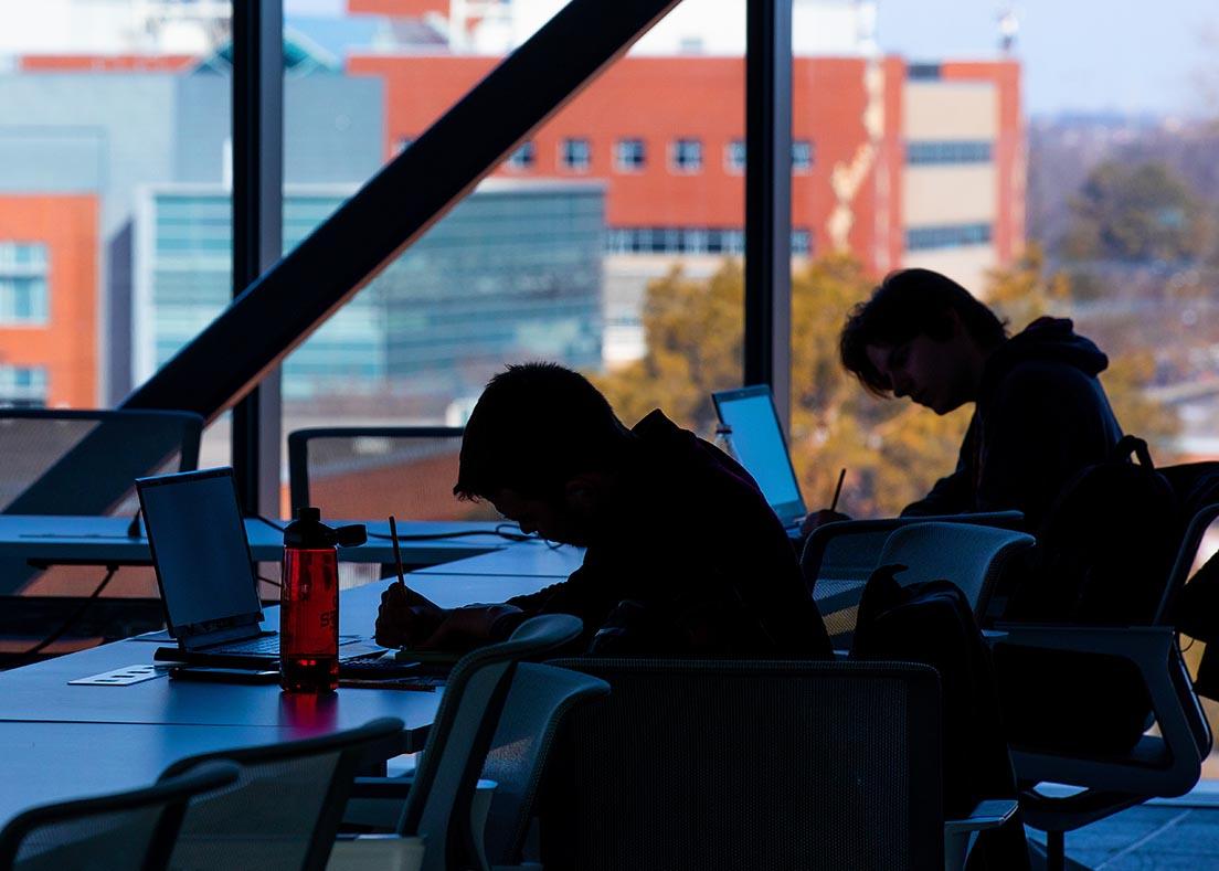 Silhouette of two students studying in the Student Innovation Center